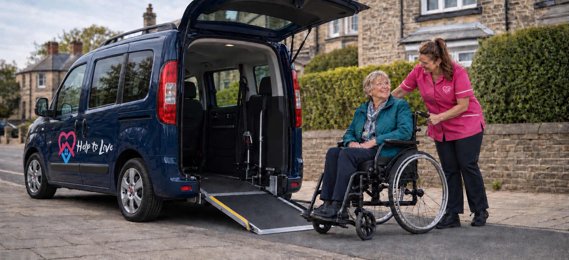A Help to Live carer supporting a wheelchair user beside the sign-written navy Fiat Doblò accessible vehicle with its ramp deployed